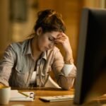 Young female student feeling tired while learning on a computer